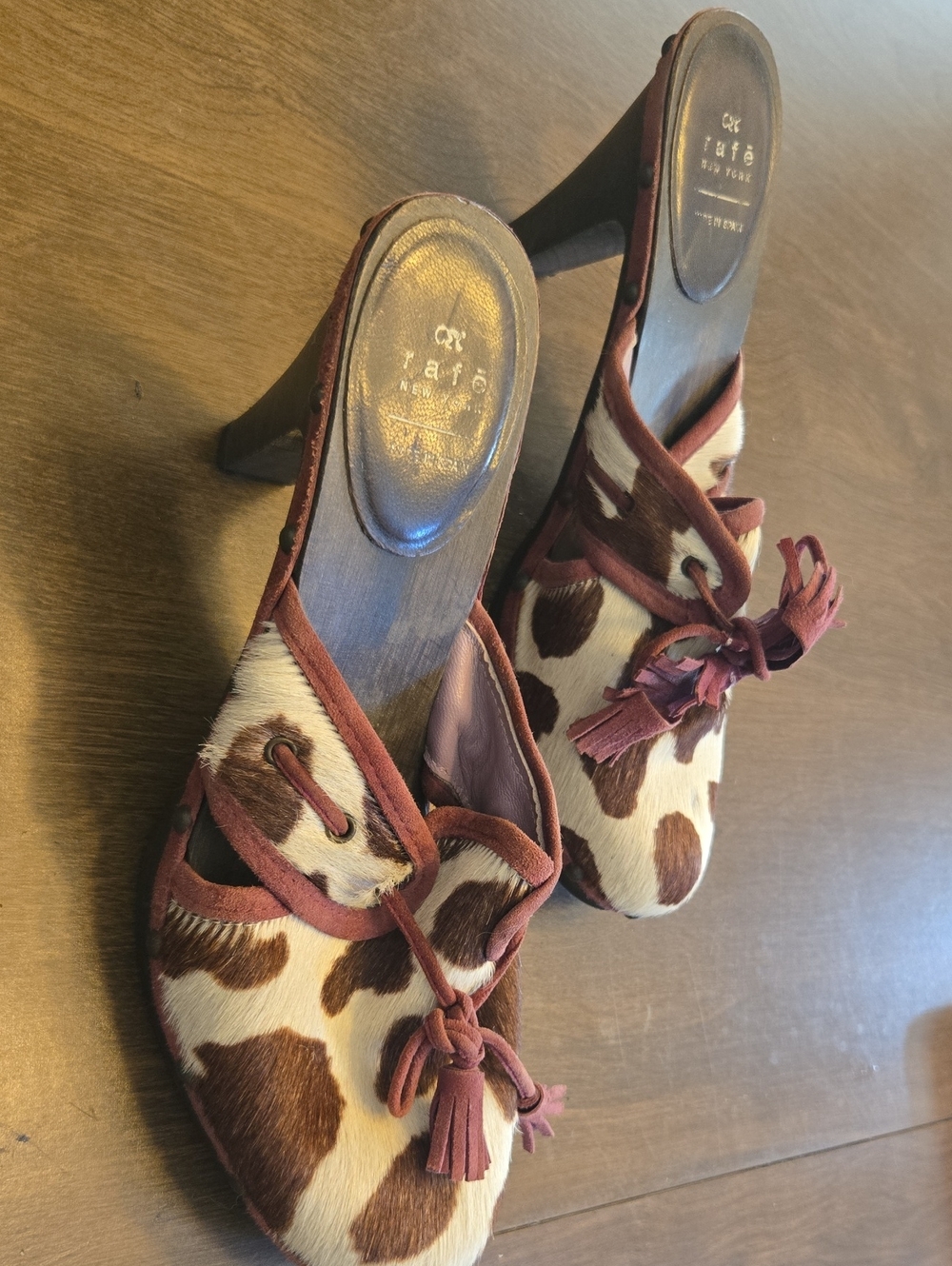 Rafe New York cowhide clogs with a brown-and-white cow print pattern.